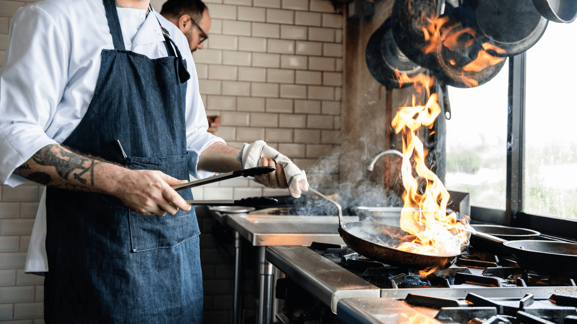 Where chefs find their food inspiration Chef cooking in a kitchen with a flame.