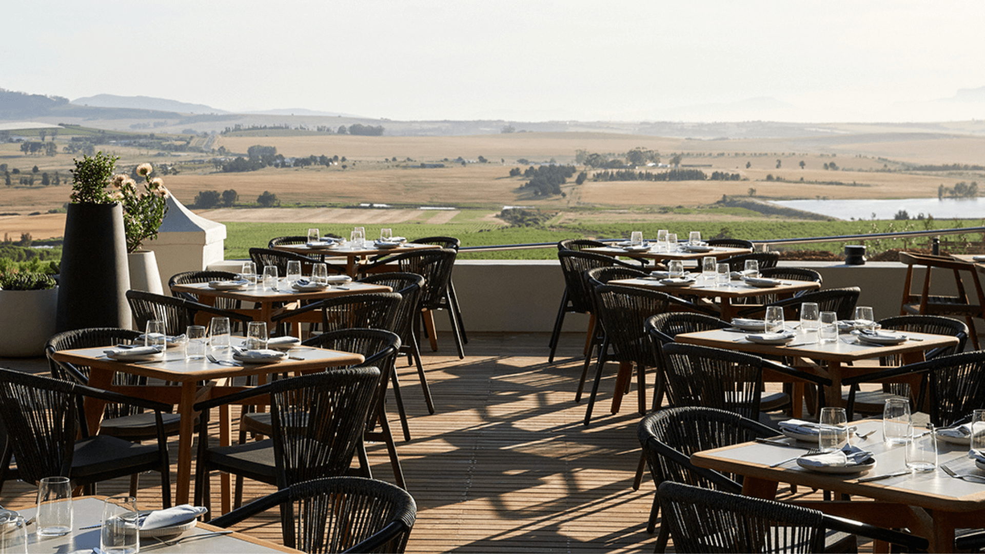 Mountain, and valley view with tables on a deck.