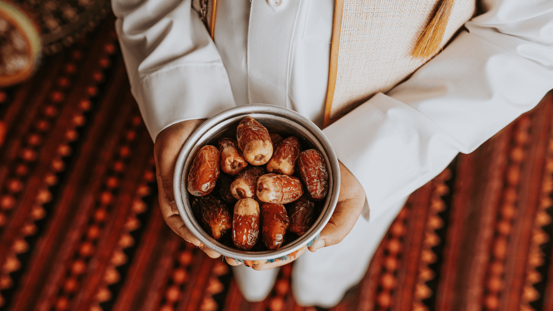 A boy holds a bowl of dates for Ramadan