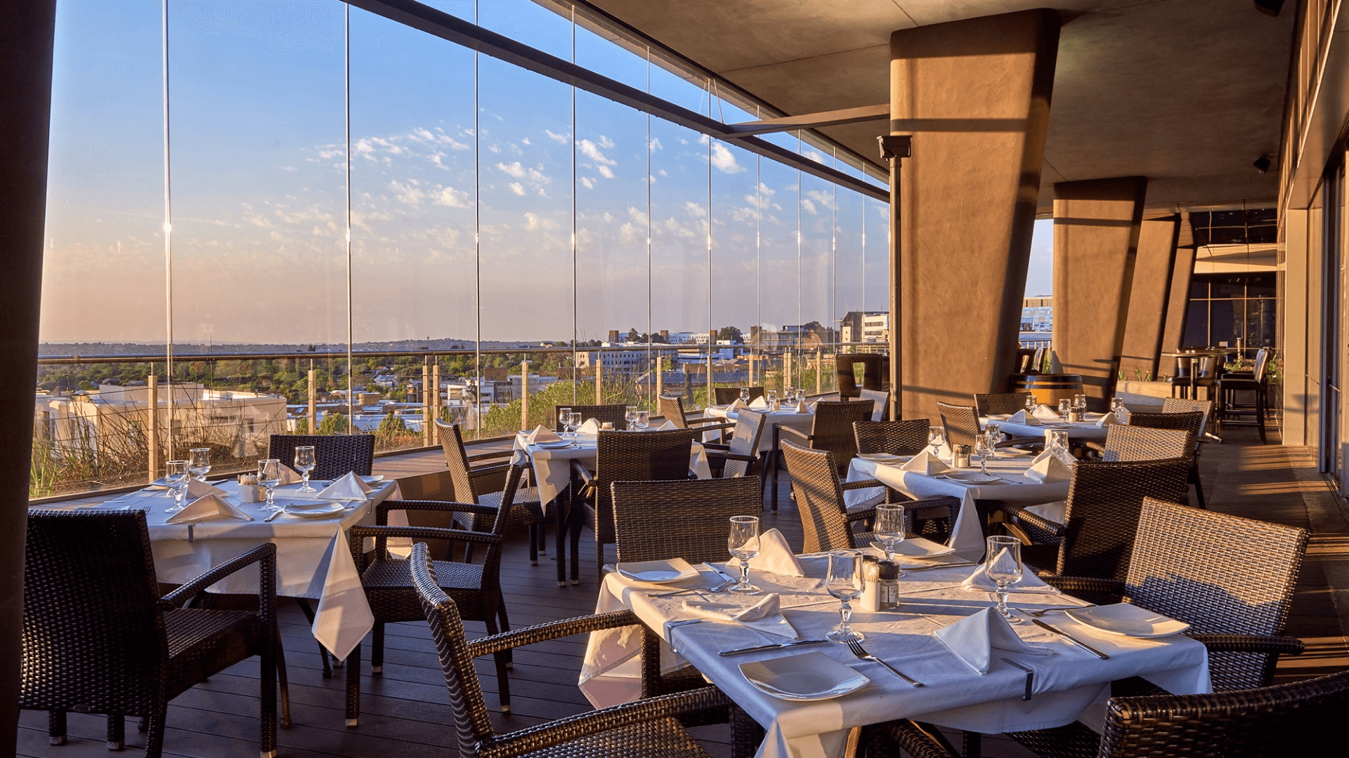 Beyond gift cards. A restaurant dining room with large windows looking out over the city at sunset.