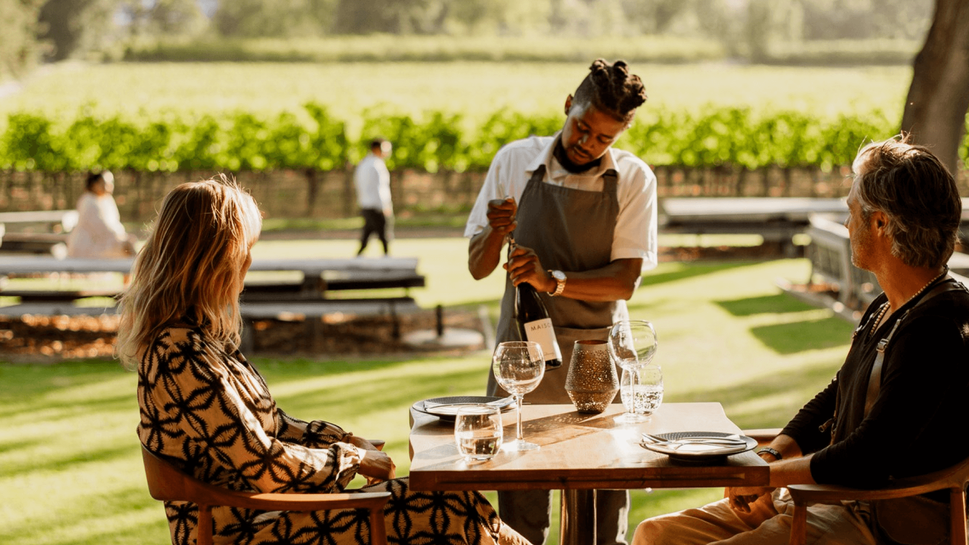 A couple served wine by a waiter at Chefs Warehouse at Maison