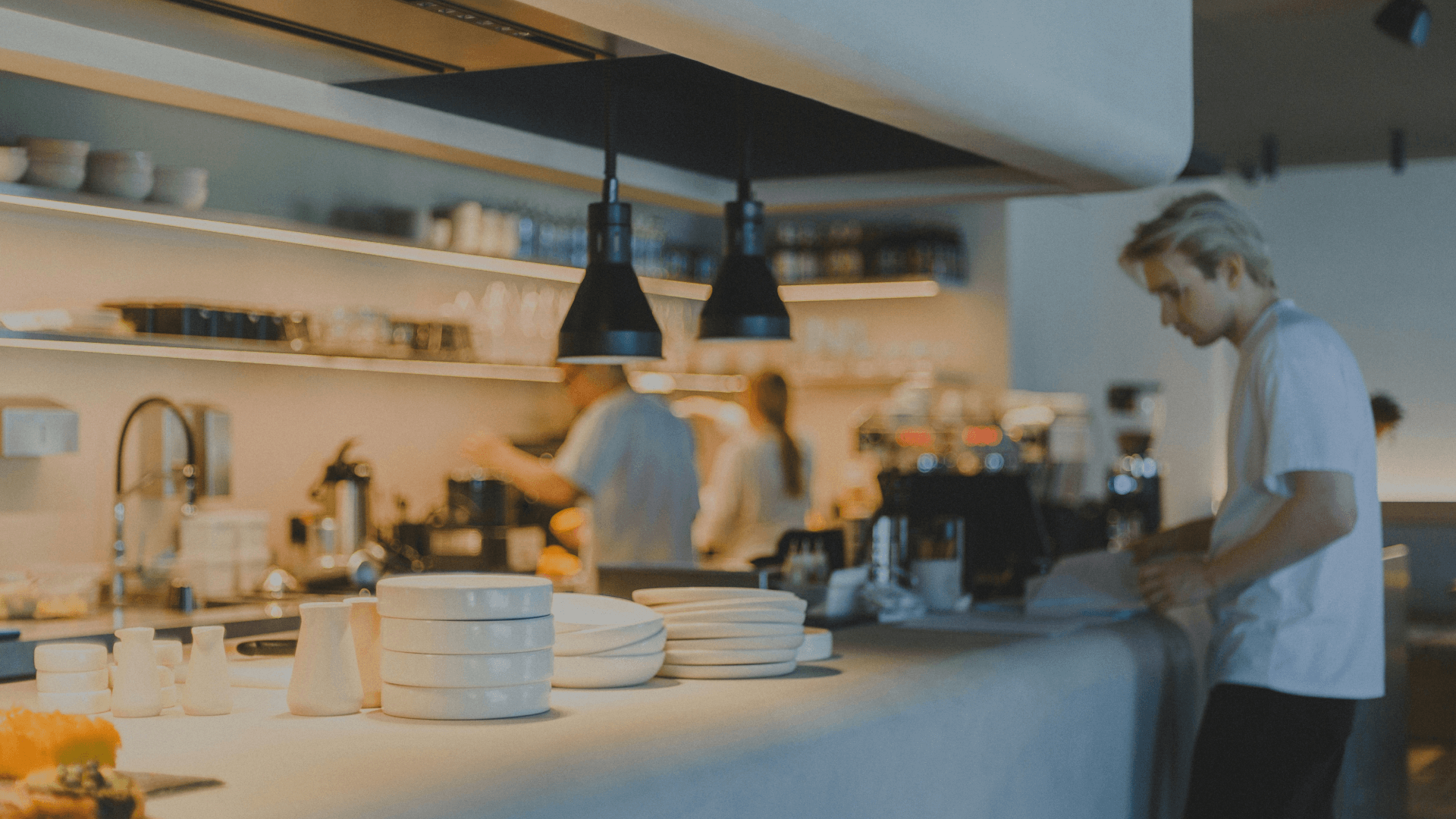 3 chefs work in a white kitchen