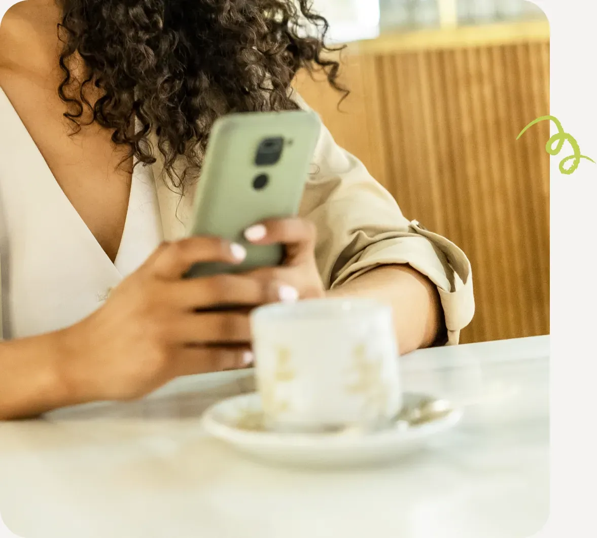 Person reading newsletter on phone at a cafe